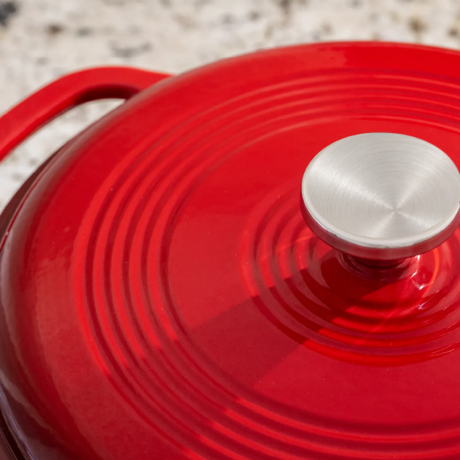 Red enamelled cast-iron Dutch oven with a brushed-metal knob